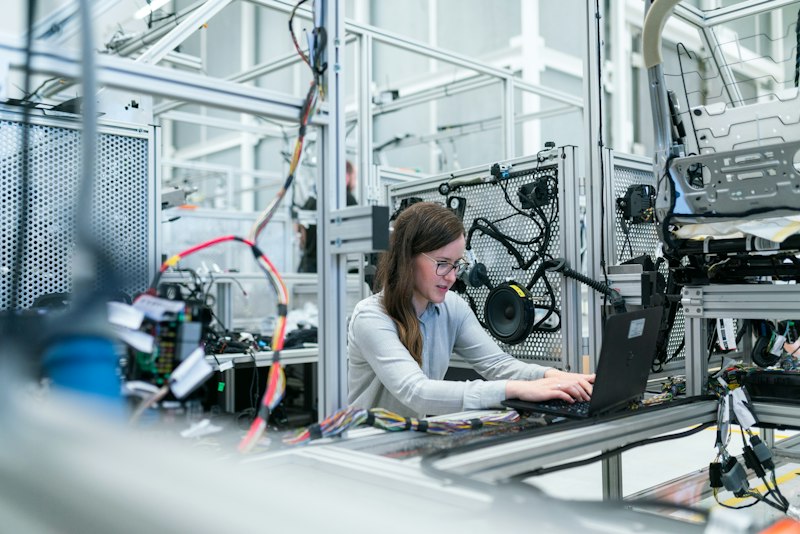 Frontline worker on a manufacturing floor reviewing a tablet